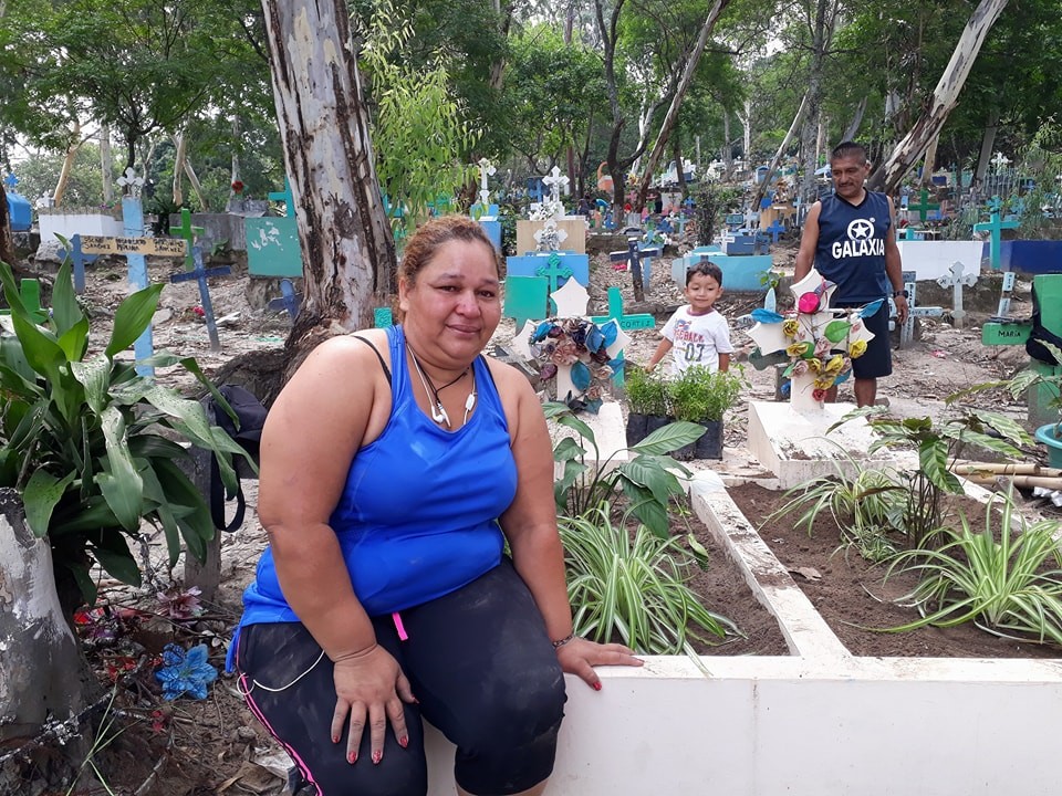 Susana Tovar descansa luego arreglar la tumba de su madre en el cementerio de Antiguo Cuscatlán, La Libertad. /Foto de Ana Torres.